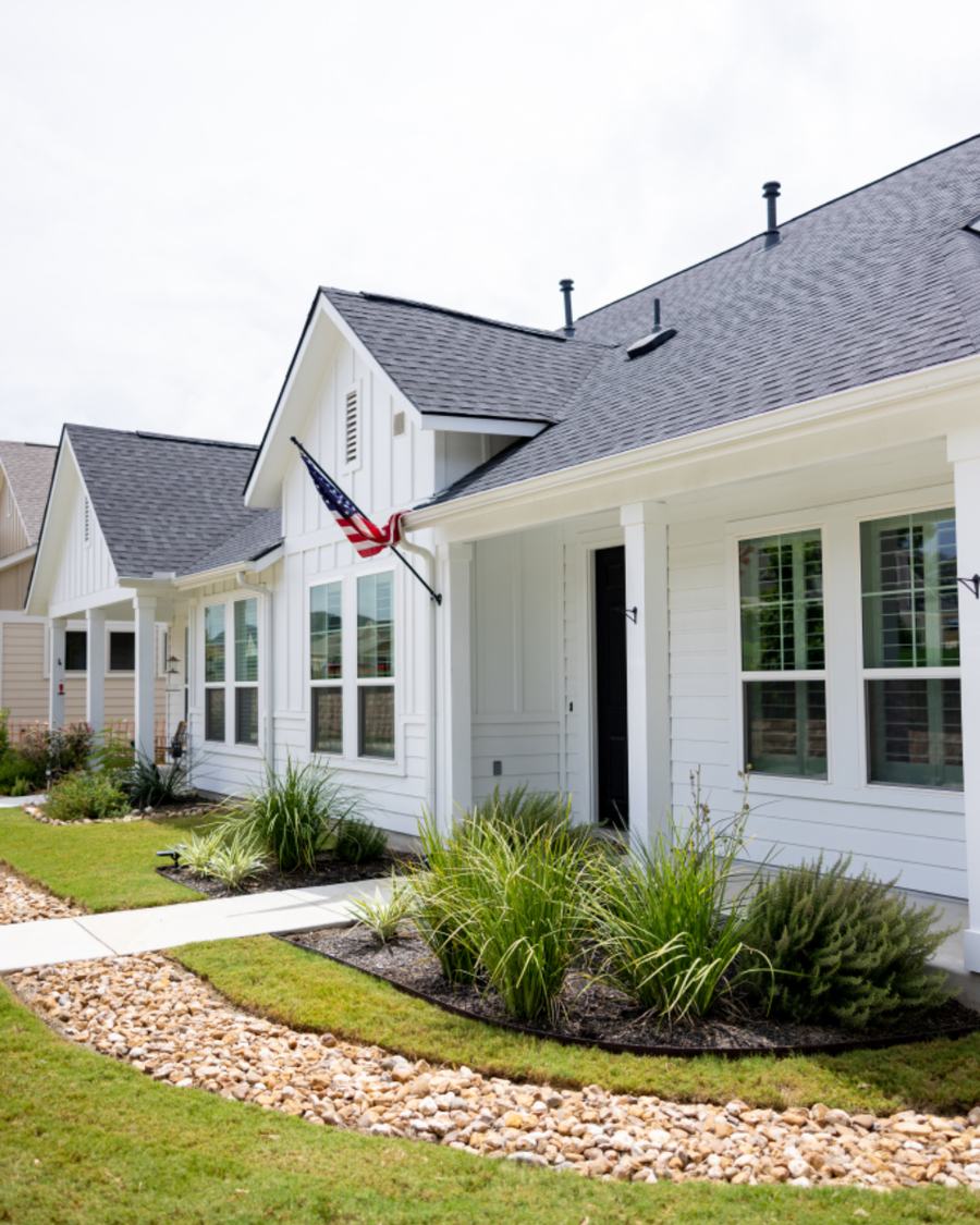 Example photo: a white house with a fresh bed and a green lawn