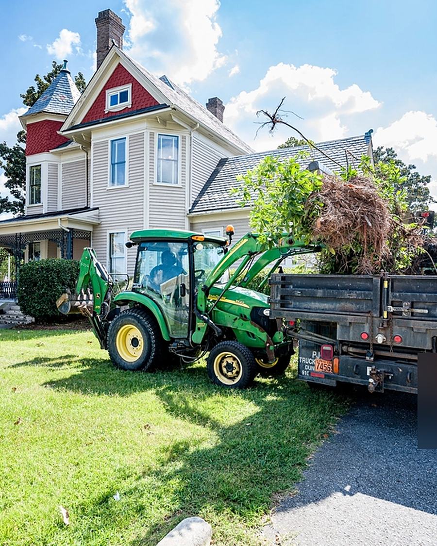 Example photo: a tractor with a dump trailer by a house