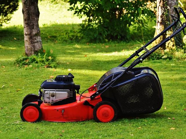 A red push mower on the grass