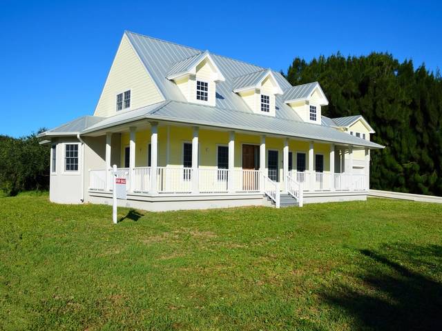 A white farmhouse with a big lawn